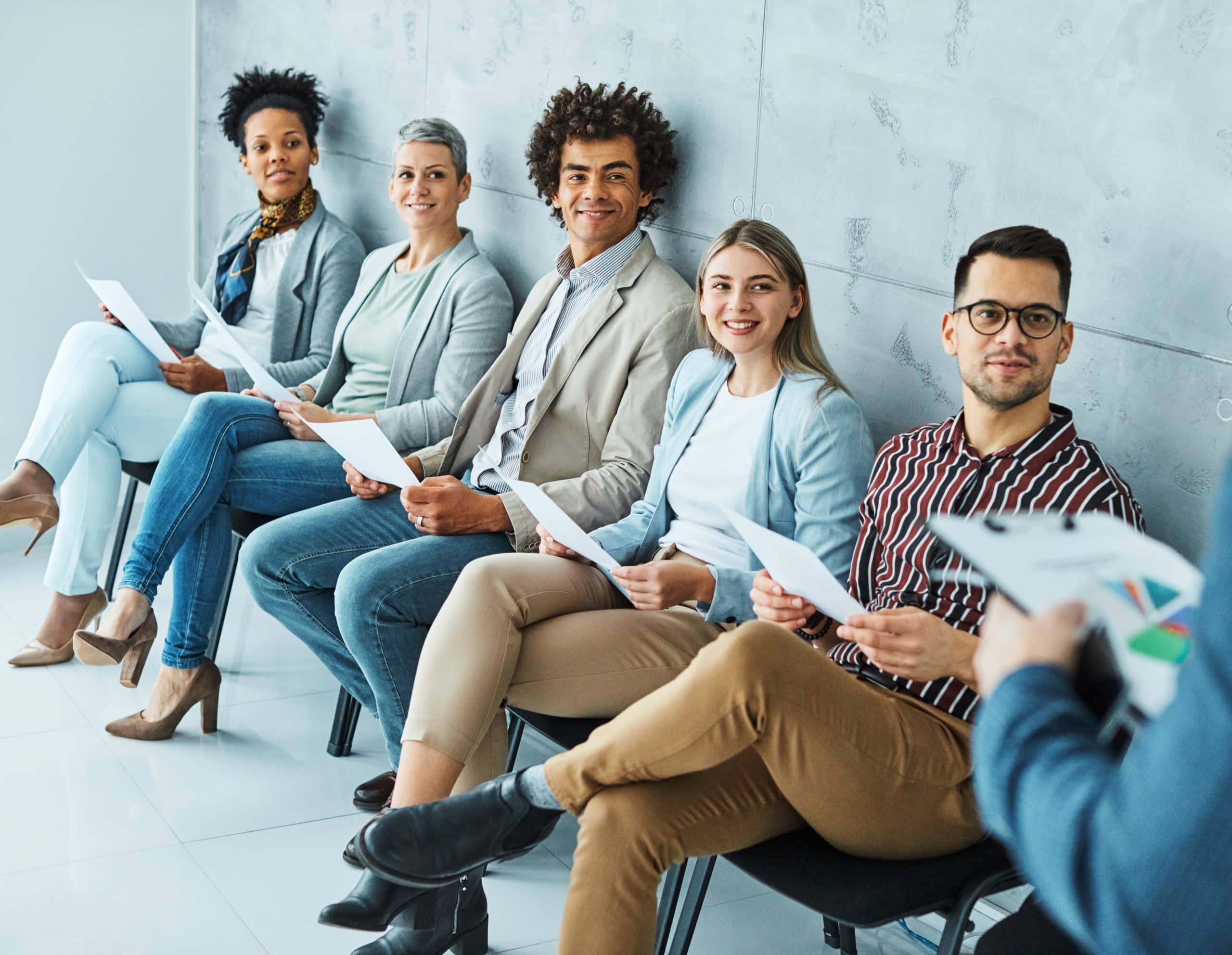 Group of diverse professionals at F3 Private Investigations meeting, holding documents and smiling attentively, ready for collaboration.