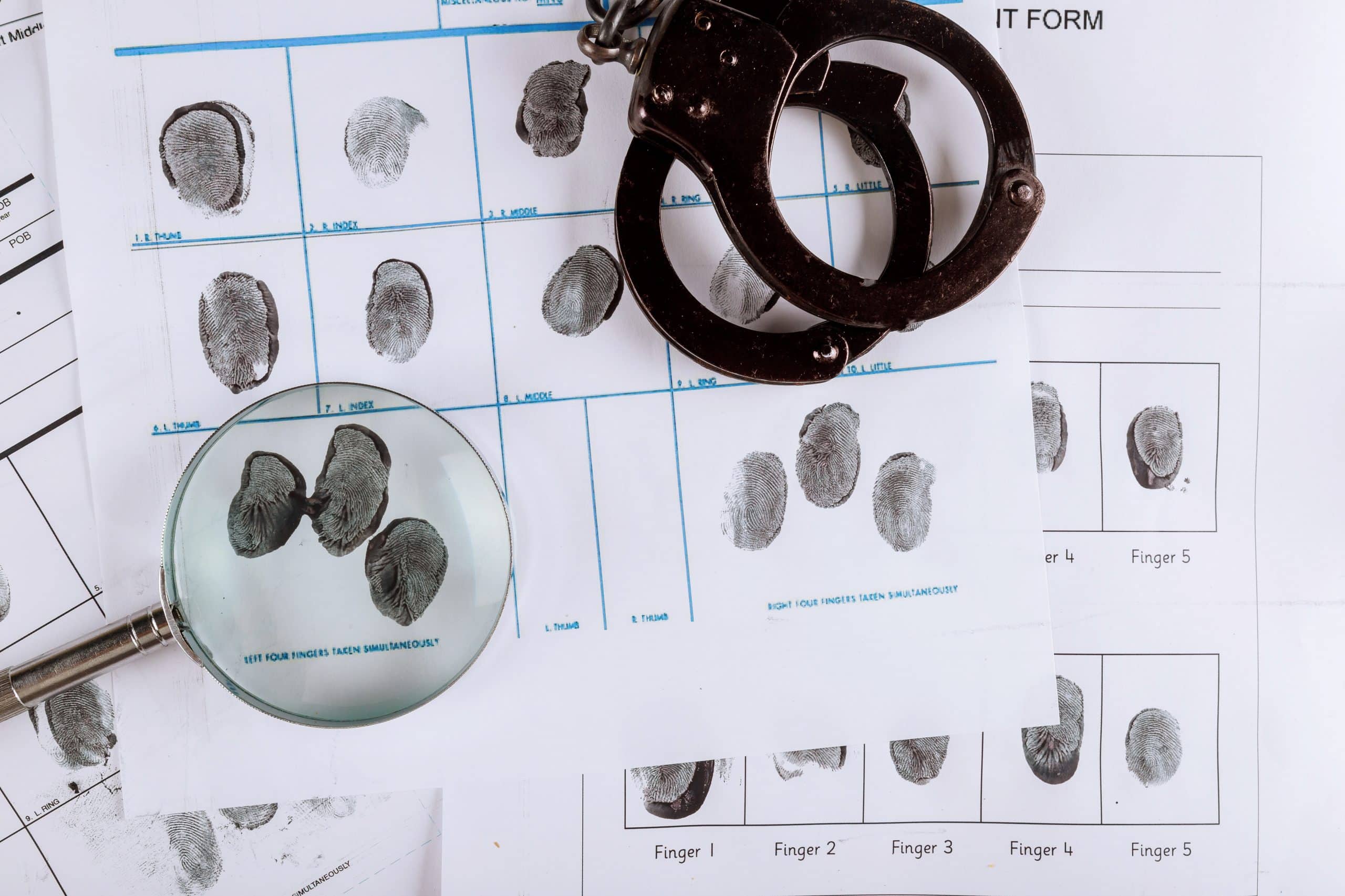 Fingerprint analysis and handcuffs at F3 Private Investigations – expert forensic services for legal and private cases.