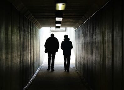 Silhouette of two private investigators walking through a dimly lit tunnel, F3 Private Investigations service.