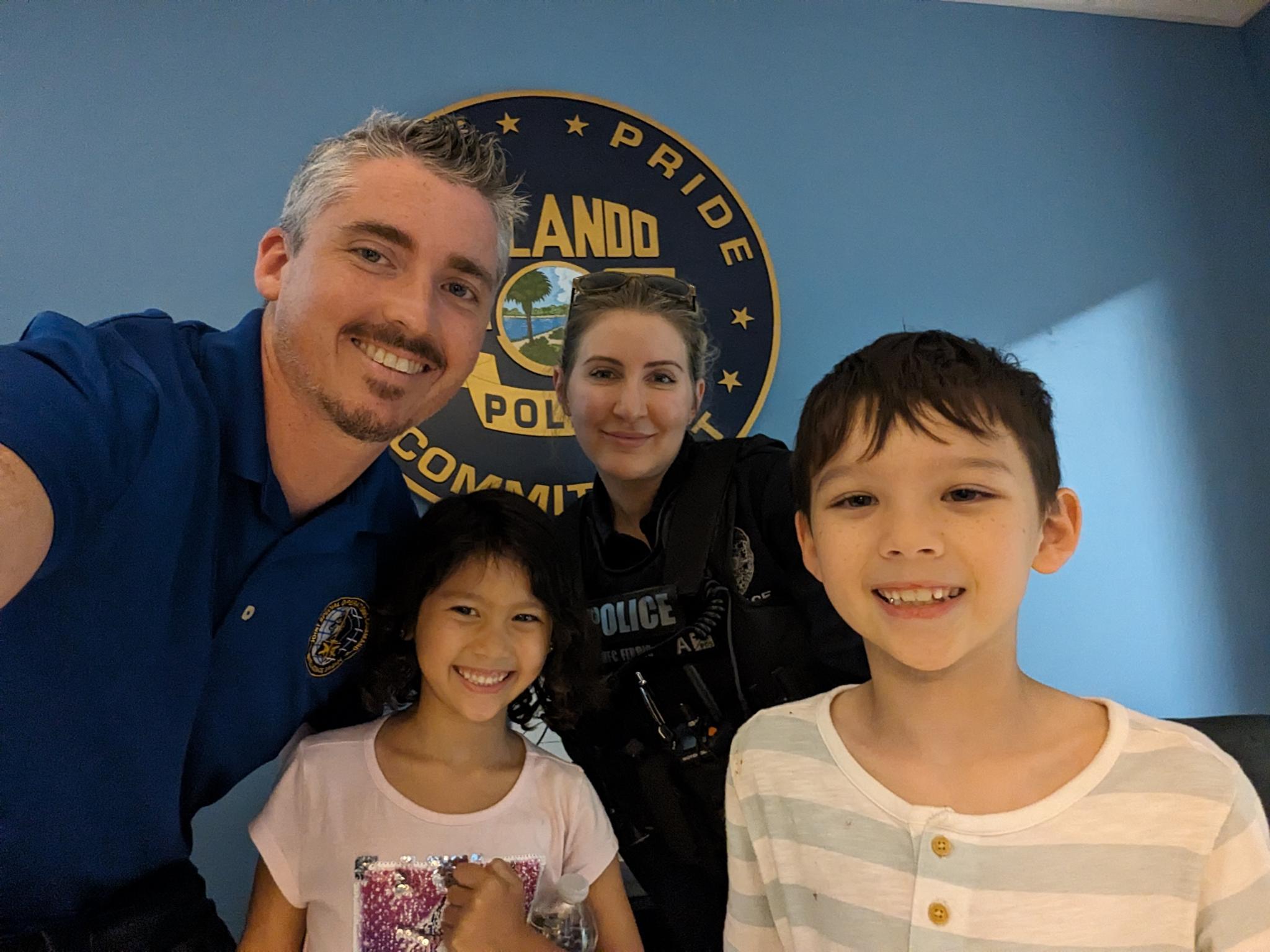 Orlando police officers with two smiling children.