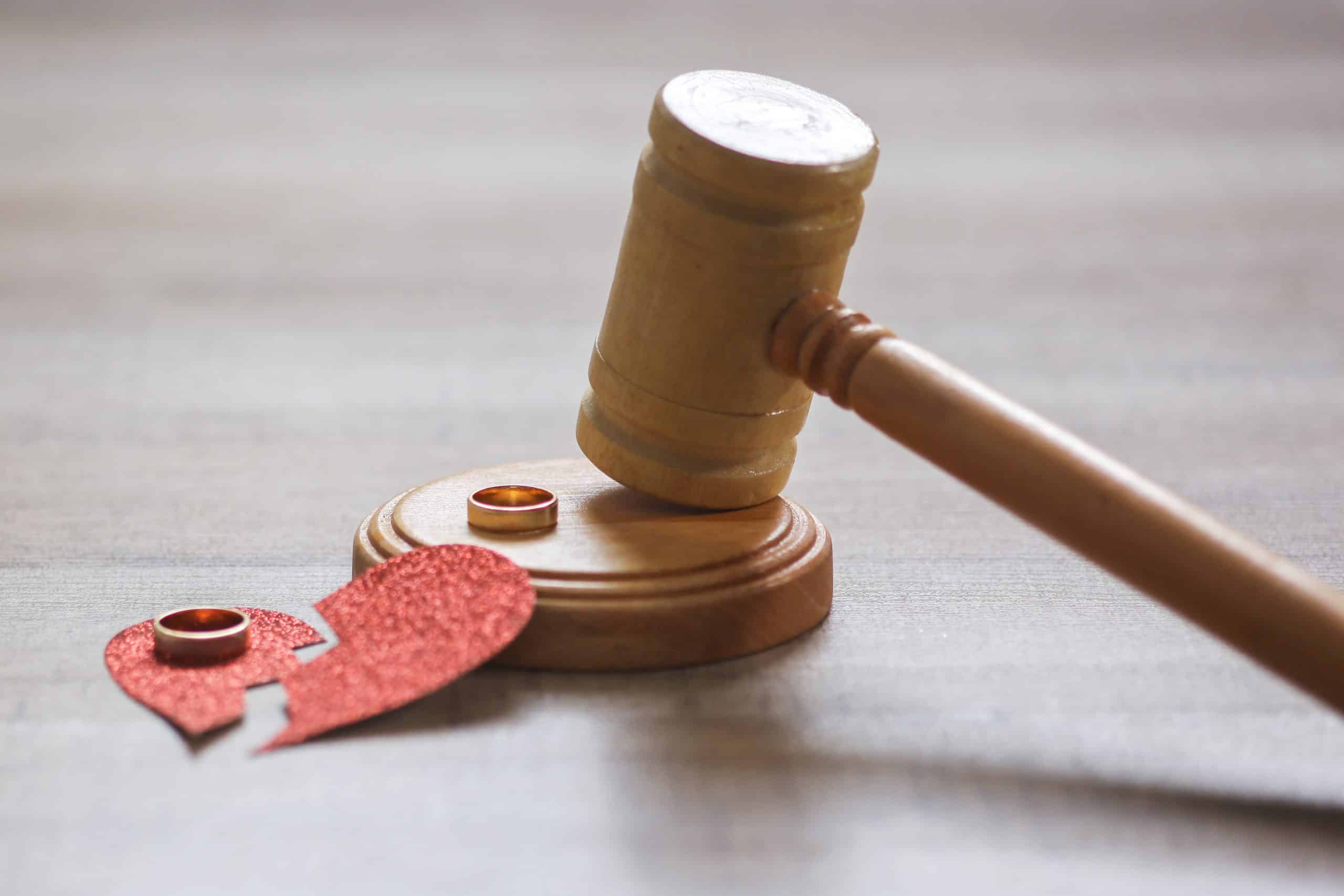 Divorce concept: gavel, broken heart, wedding rings.