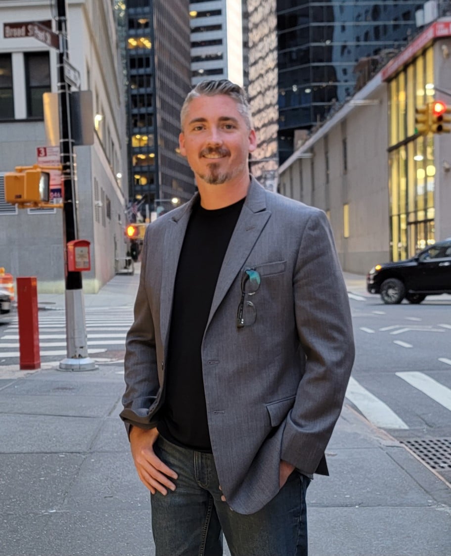 Man in gray blazer on city street