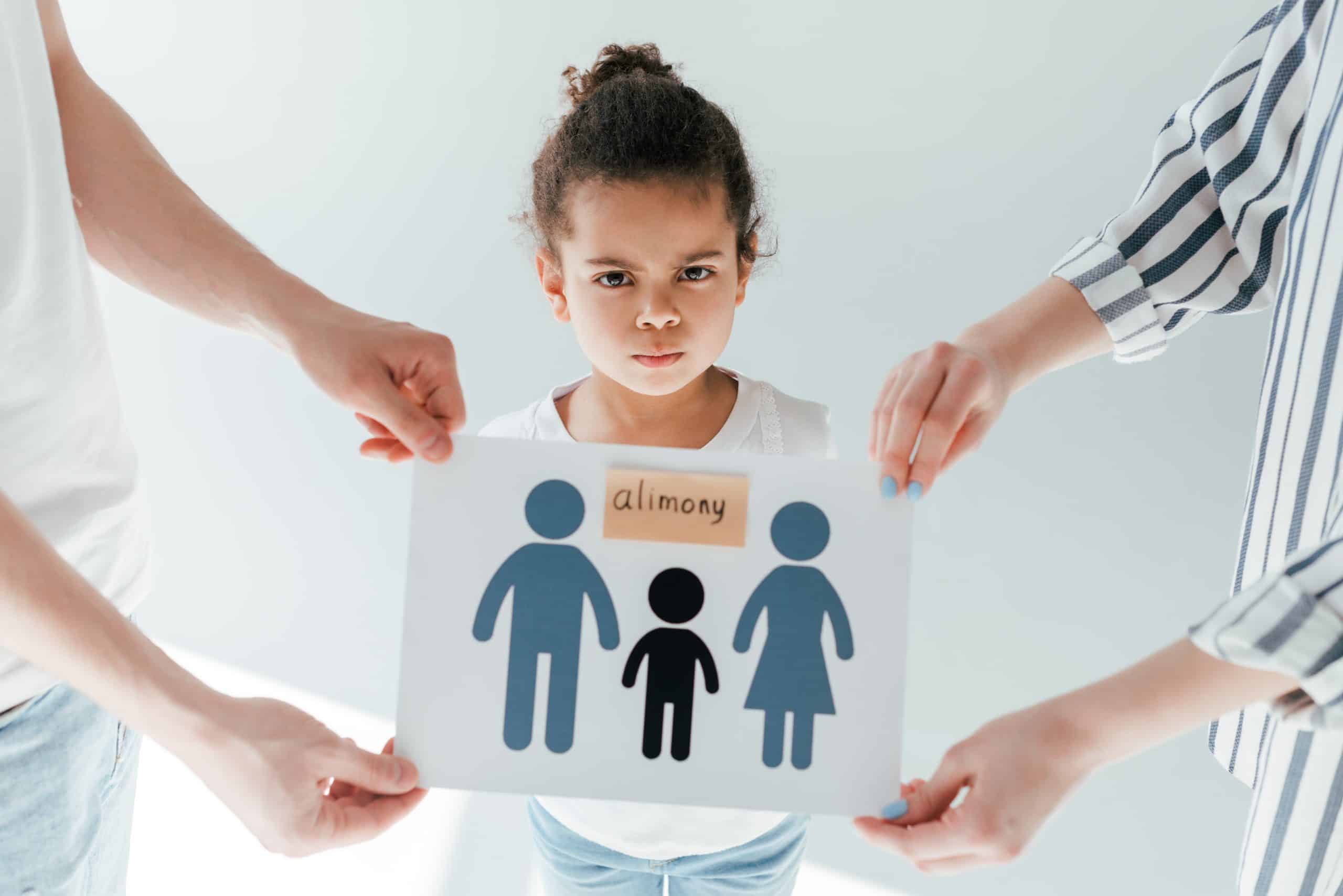 Child with alimony sign and worried expression