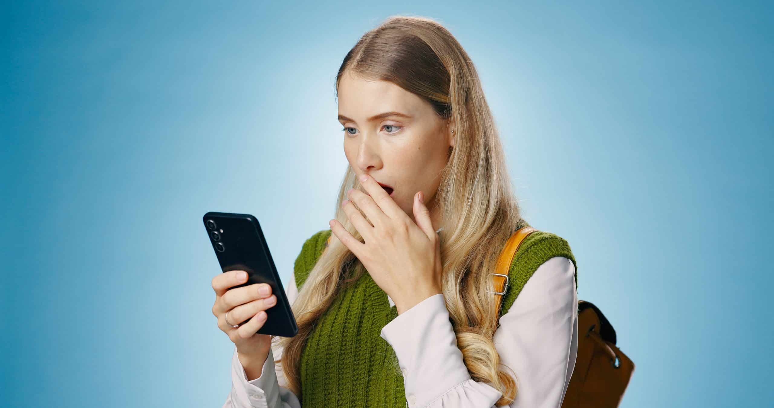 Surprised woman looking at smartphone screen